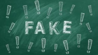 The word FAKE and exclamation marks written in chalk on a greenboard. Information and disinformation concept. Fake news.