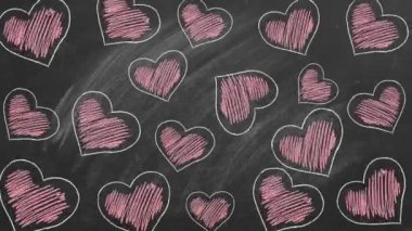 Birçok kırmızı kalp okulun kara tahtasına tebeşirle çizilir. Sevgililer Günü, aşk, şefkat konsepti.