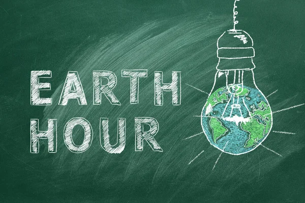 スクールグリーンボードのチョークに描かれたEarth Hour手をレタリングした軽い球根 世界を救う 私たちの惑星を保存する — ストック写真