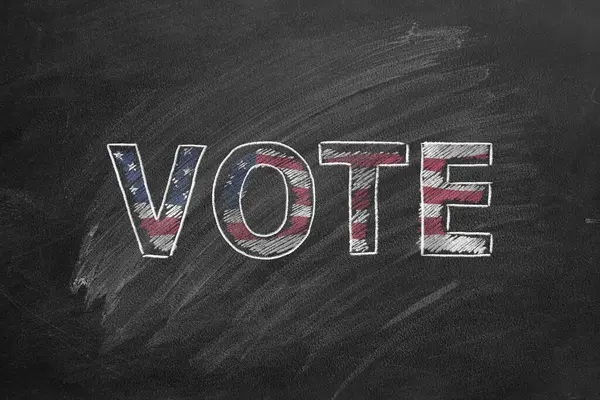 黑板上手写的单词Vote 在美国选举中投票 美国总统选举 图库照片