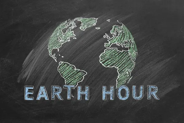 学校の黒板にチョークで描かれたEarth Hour手をレタリングしたグローブ 世界を救う 私たちの惑星を保存する ストックフォト