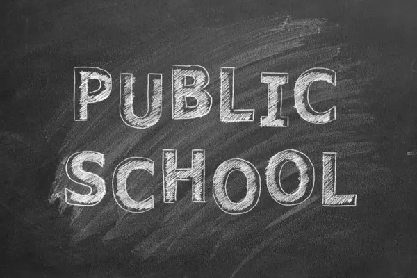 黑色黑板上的公立学校手绘课文 免版税图库照片