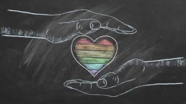 Gökkuşağı kalpli iki erkek eli. LGBTQ hakları ve cinsiyet eşitliği kavramı. Gurur ayı.