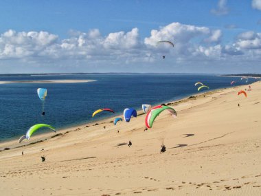 People paragliding at the Great Dune of Pilat, Arcachon Basin, Nouvelle Aquitaine, France. clipart