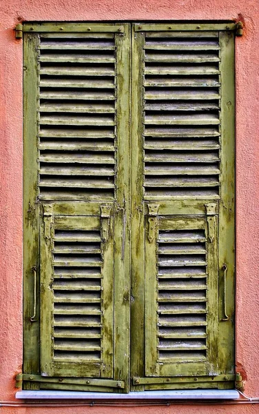 旧的和风化的绿色百叶窗在粉刷过的墙上 Villefranche Sur Mer 图库照片
