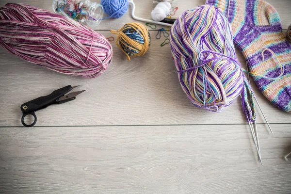 木製のテーブルの上に 手の編み物のための色の糸 編み物針やその他の項目 — ストック写真