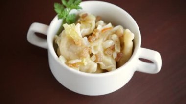 Tahta bir masada patates ve kızarmış soğanla pişirilmiş hamur köftesi..