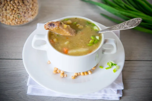 木のテーブルの上で乾燥したエンドウ豆のスープを — ストック写真