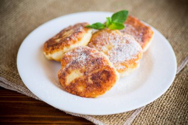 Masadaki tabakta pudra şekerli tatlı peynirli kekler..