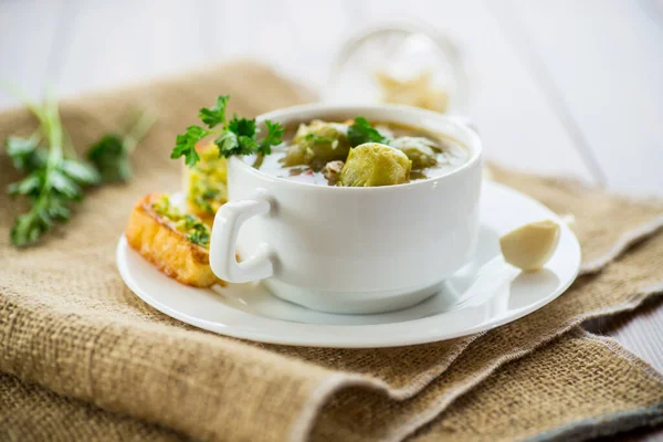 木のテーブルの上のプレートに ブリュッセルのもやし クルトンと熱い調理スープ — ストック写真