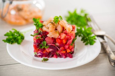 Haşlanmış sebzeli salata. Tabakta tuzlanmış balık, ahşap bir masada..