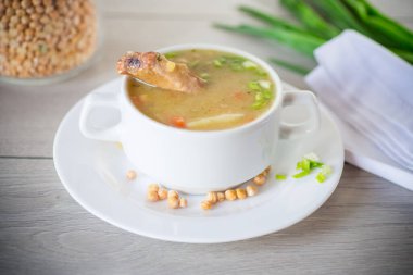 Kurumuş bezelye çorbası, bir tabak otla, ahşap bir masada..