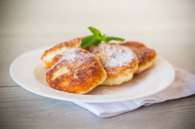 Masadaki tabakta pudra şekerli tatlı peynirli kekler..