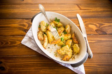 Patatesler susam tohumları, otlar ve baharatlarla fırında seramik bir şekilde pişirildi..