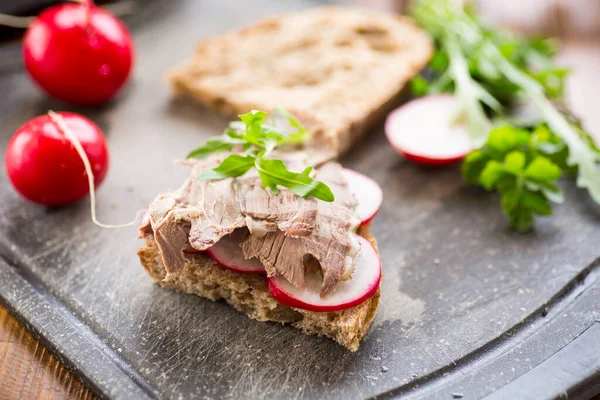 Smörgås Med Bakat Kött Rädisa Och Örter Ett Träbord — Stockfoto