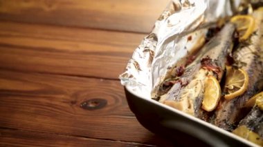 Baharatlı ve folyolu fırında balık, seramik formda..