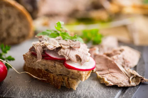 木製のテーブルの上に焼き肉と大根とハーブのサンドイッチ — ストック写真