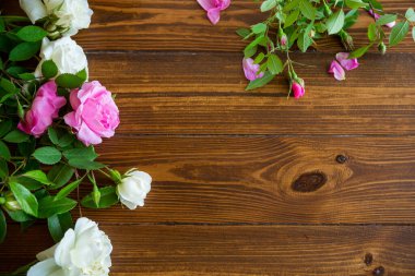 Siyah ahşap bir masada pembe ve beyaz güllerin çiçek arkaplanı.