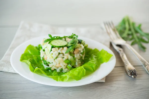 木のテーブルの上の皿に豆や米やキュウリなどの野菜を盛った新鮮な夏のサラダ — ストック写真