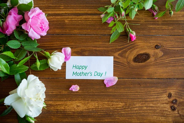 stock image Floral background of pink and white roses on a dark wooden table