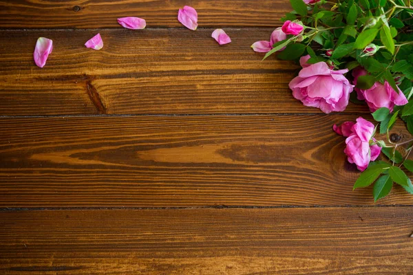 濃い木製のテーブルの上にピンクのバラの花の背景 — ストック写真