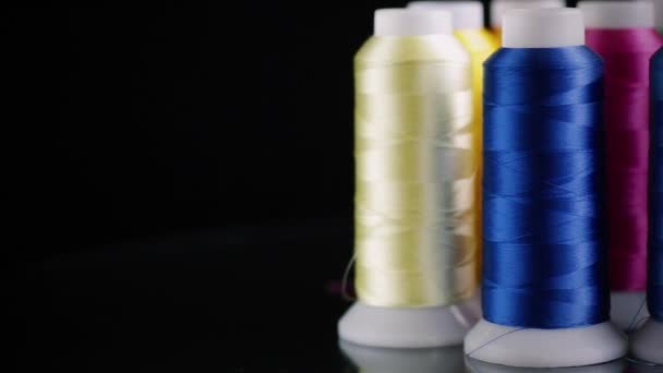 黒い背景に隔離された異なる色の縫製糸のセット — ストック動画