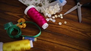 Ahşap bir arka planda dikiş giysileri için bir takım alet ve iplikler..