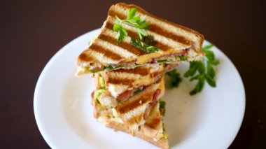 İçinde sosis, peynir ve sebzeyle doldurulmuş kızarmış ekmek, masada bir kasede...