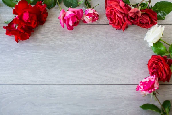 薄木製のテーブルの上にピンク その他のバラの花の背景 — ストック写真