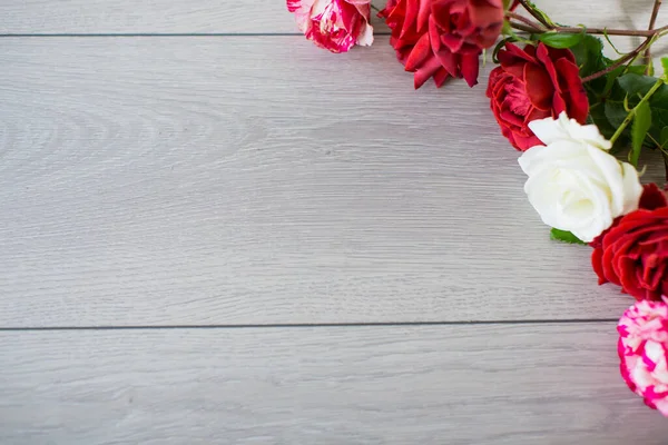 薄木製のテーブルの上にピンク その他のバラの花の背景 — ストック写真