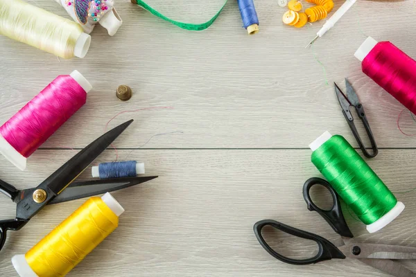 stock image a set of tools and threads for sewing clothes, on a wooden background.