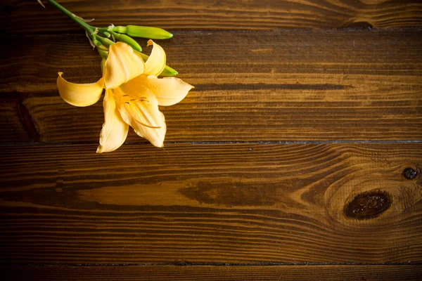 暗い木製のテーブルの上に美しい黄色のユリの花束 — ストック写真