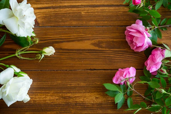 濃い木製のテーブルの上にピンクと白のバラの花の背景 — ストック写真