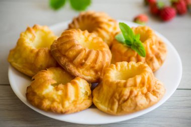 Tahta bir masada taze çilek ve nane şekerli kaymaklı kek pişirdim..