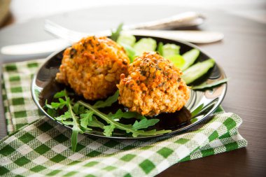 Tahta bir masada taze sebzelerle pişirilmiş köfteler..