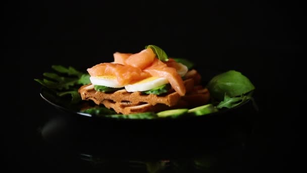 薄味の赤魚と調理されたサンドイッチ キュウリとハーブでゆで卵 黒の背景に隔離された — ストック動画