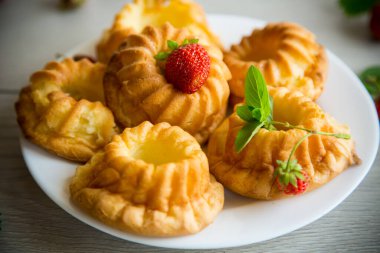 Tahta bir masada taze çilek ve nane şekerli kaymaklı kek pişirdim..