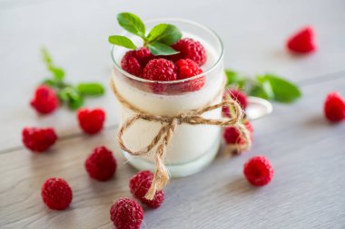 Ahşap bir masada olgun kırmızı ahudududulu ev yapımı yoğurt..