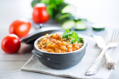 Ahşap bir masada kabak ve diğer sebzelerle pişirilmiş beyaz fasulye..