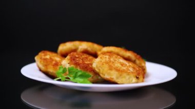 Siyah arka planda izole edilmiş, otlarla dolu bir tabakta kızartılmış balık pirzolası..