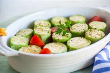 Domatesli çiğ kabak, ahşap bir masada seramik bir şekilde pişirilmeye hazır..