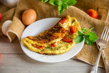 Hafif ahşap arka planda domatesli omlet. Kahvaltı için sağlıklı diyet yemekleri..