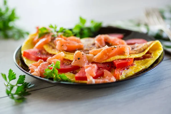 煎蛋卷 西红柿 蔬菜和少许咸红鱼片 放在木制上 — 图库照片