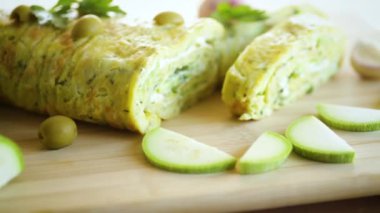 Tahta bir tahtanın üzerinde sarımsaklı peynirli sebze kabağı rulosu..