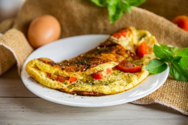 Hafif ahşap arka planda domatesli omlet. Kahvaltı için sağlıklı diyet yemekleri..