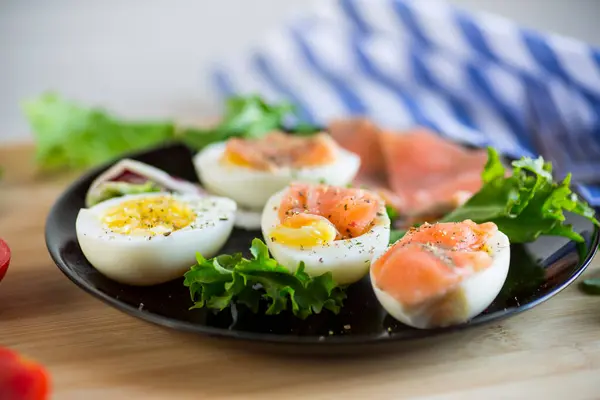 用咸红鱼 香草和调味品在木制桌子上的盘子里煮鸡蛋 — 图库照片