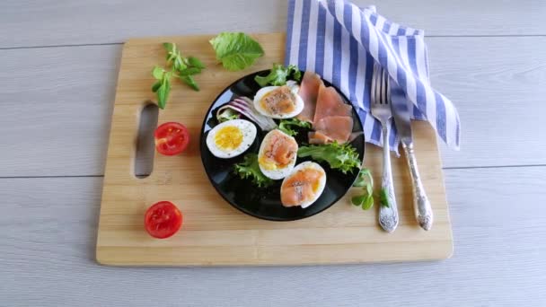 木のテーブルの皿に塩漬けの赤魚 ハーブ 調味料が付いている卵 — ストック動画