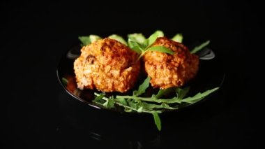 Siyah arka planda izole edilmiş taze sebzeli bir tabakta köfte..