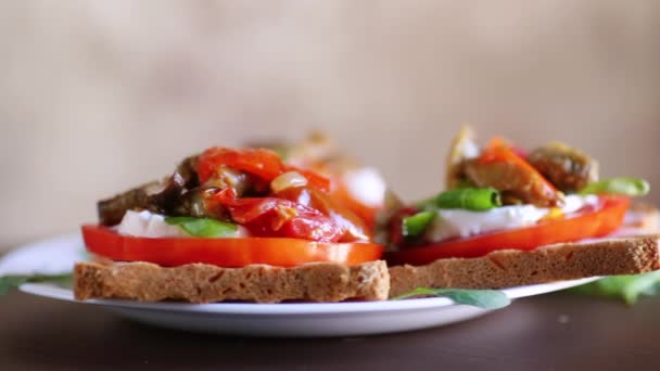 トマト モッツァレラ フライドナスと木製のテーブルの皿にキノコで作られたサンドイッチ — ストック動画