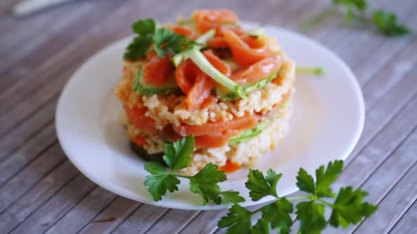 木のテーブルの上に 皿にハーブと塩漬けの赤魚 キュウリ その他の野菜で煮た白米 — ストック動画